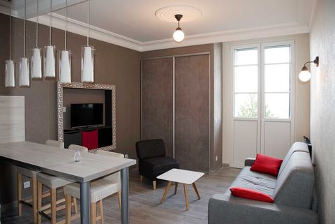 Coin repas, placards et porte-fenêtre du studio meublé à Évian-les-Bains